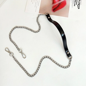 Detail of silver metal flat chain with black glossy faux leather shoulder strap and lobster clasps