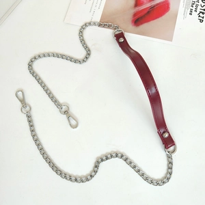 Macro detail of silver metal chain strap with burgundy PU leather shoulder guard and lobster hooks