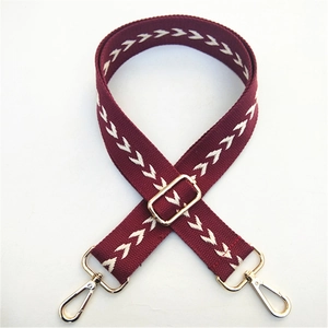 Détail de la bandoulière ethnique bordeaux avec flèches blanches et crochets dorés