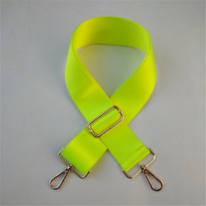 Dettaglio di una tracolla regolabile in nylon giallo neon con ganci in metallo argento