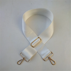 Dettaglio tracolla in nylon bianco con fibbie in metallo dorato regolabili