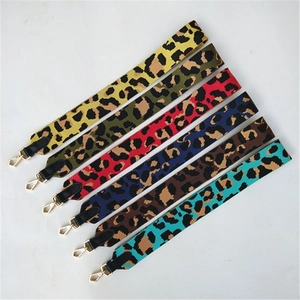 Détail des bandoulières léopard colorées avec crochets dorés et finitions en cuir noir
