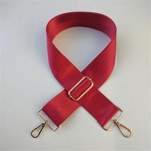 Dettaglio della tracolla in nylon rosso con ganci girevoli e fibbia in metallo dorato