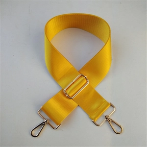 Dettaglio della tracolla regolabile in nylon giallo brillante con moschettoni in metallo dorato