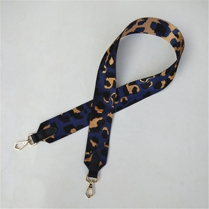 Détail de la bandoulière large imprimé léopard avec mousquetons dorés et toile bleue