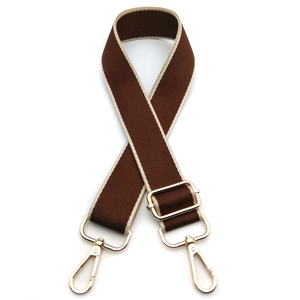 Detail of dark brown adjustable bag strap with cream edges and gold metal swivel lobster clasps
