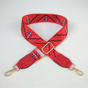 Close-up of red ethnic pattern nylon strap with gold metal hooks and leather ends