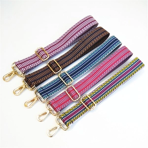 Detailed view of bohemian woven striped bag straps with shiny gold metal hardware clips