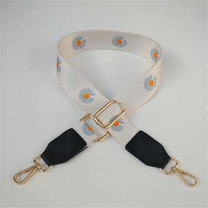 Detail of adjustable canvas bag strap with daisy floral print and gold lobster clasps