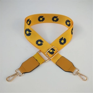 Detail view of adjustable yellow nylon strap with daisy prints and gold metal lobster hooks