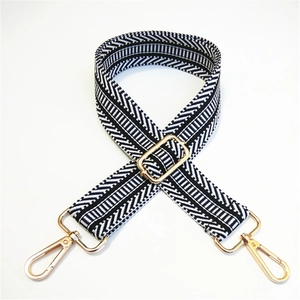 Detail showing high-quality black and white striped woven strap with gold metal swivel hooks