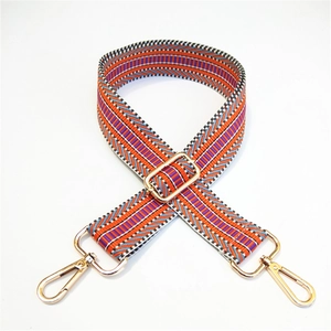 Close-up of adjustable geometric striped bag strap with gold metal lobster clasps