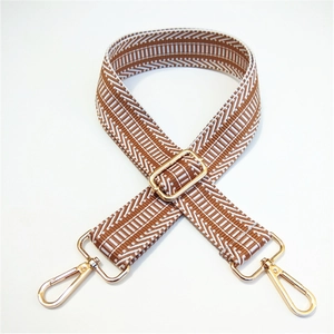 Detail of adjustable caramel and white geometric stripe wide shoulder strap with gold hooks