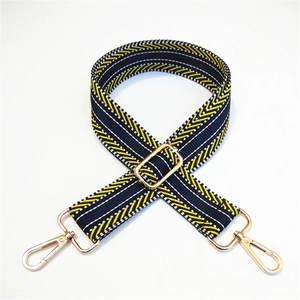 Close-up of adjustable striped bag strap with navy blue geometric weave and gold hardware