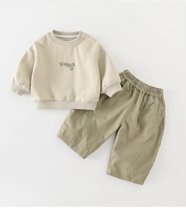 Detail of baby autumn set featuring YOOSA patch embroidery on a beige long-sleeve sweatshirt