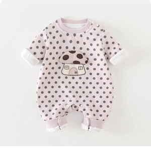 Detail of baby romper with mushroom embroidery, polka dot pattern and snap buttons