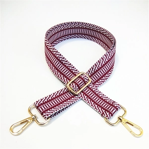 Detail of adjustable wide shoulder strap with burgundy V-shape weaving and gold metal hooks