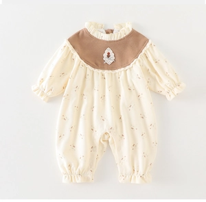 Close-up of baby floral romper featuring delicate lace flower and brown ruffled collar