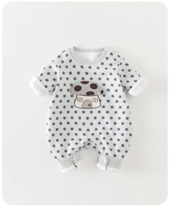 Close-up of baby romper featuring detailed cartoon mushroom embroidery and polka dots