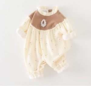 Close-up of baby floral romper featuring a ruffled lace collar and embroidered patch details