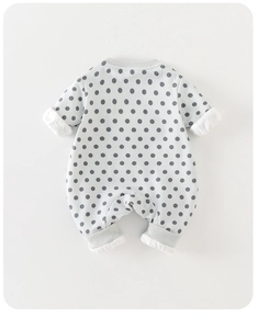 Detailed view of polka dot pattern and ribbed cuffs on cotton baby romper