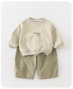 Detail of baby autumn beige long-sleeve sweatshirt and olive green shorts set