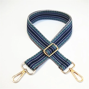 Close-up of adjustable woven shoulder strap with blue and green herringbone pattern and gold clips
