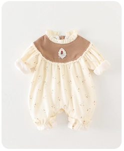 Detail of floral baby romper featuring ruffled lace collar and ribbed cotton texture