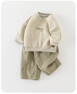 Detail of baby autumn two-piece set featuring beige cotton sweatshirt and olive green pants