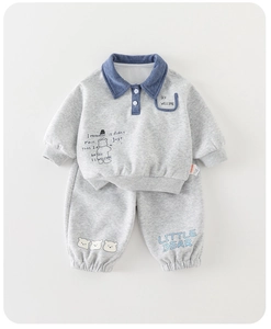 Détail de l'ensemble de jogging gris pour bébé avec col polo et broderie d'ourson