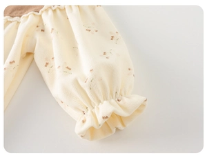 Detail of baby floral corduroy sleeve with elastic ruffled cuff and texture