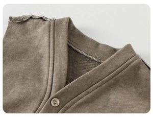 Detail of vintage washed cotton vest with raw edge V-neck and beige button for toddlers