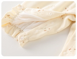 Detail of floral baby bodysuit featuring ribbed cotton fabric and snap fasteners