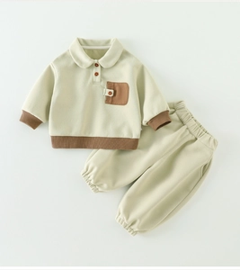 Détail de l'ensemble sweat polo bébé garçon avec bordures tricotées brunes et poche