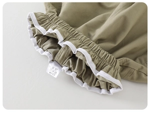 Detail of baby cotton shorts showing elastic waistband with white ruffled trim edge