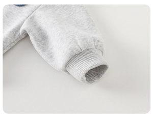 Détail des poignets côtelés d'un pull en tricot gris chiné pour bébé avec finitions