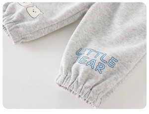 Détail du jogging bébé avec poignets élastiques gris et logo imprimé Little Bear
