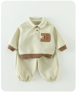 Détail de l'ensemble polo beige pour petit enfant avec finitions contrastées brunes et coton