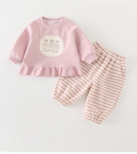 Close-up of pink toddler sweatshirt with rabbit print, happy hour text and ruffled hem detail