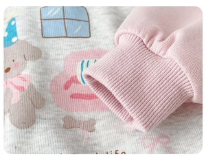 Close-up of baby sweatshirt featuring cartoon bear prints and pink ribbed elastic cuffs