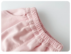 Close-up of pink ribbed knit baby pants featuring elastic waistband and detailed stitching
