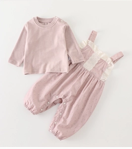 Detail of floral infant overalls with white lace trim and purple long-sleeve cotton T-shirt