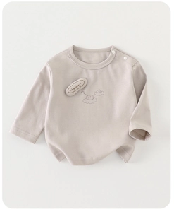 Détail du t-shirt bébé en coton avec boutons à l'épaule et écusson hérisson mignon