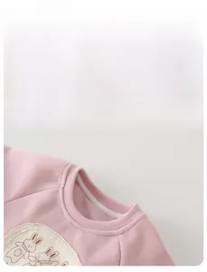 Detail of pink girls cotton sweatshirt with ribbed collar and cute lace rabbit patch