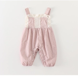 Close-up of pink cotton baby romper with white lace embroidery and snap button closure