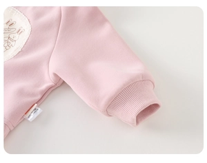 Detail of pink cotton sweatshirt featuring a rabbit patch with lace and ribbed cuffs