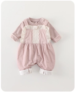 Detail view of pink floral baby romper with white lace trim and button closure