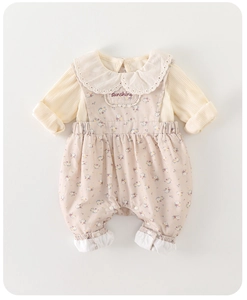 Detail of cream ribbed top with lace collar and purple floral overalls for infants