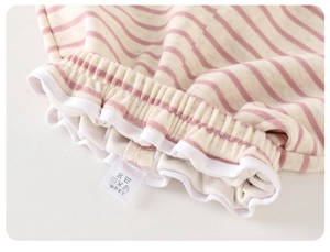 Detail of baby girl striped cotton shorts featuring elastic waist and ruffled edges