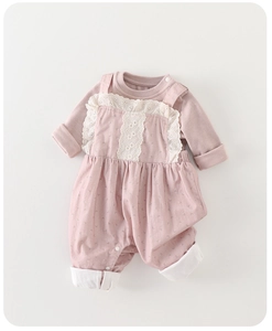 Detail of pink baby romper showing soft knit fabric and white lace embroidery texture